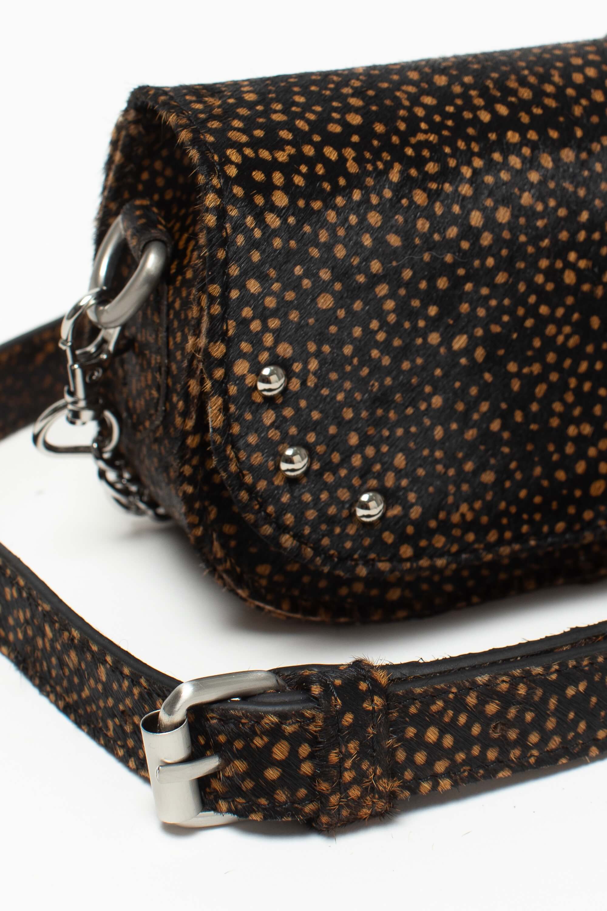 Détail du sac bandoulière Alice Fauve de Charlay Stone en cuir pony animalier imprimé noir à pois marron.